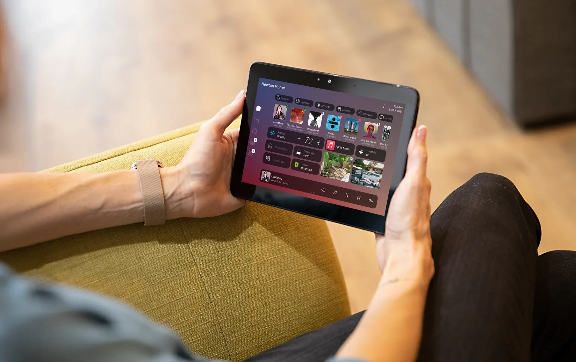 Person using a tablet for entertainment control.