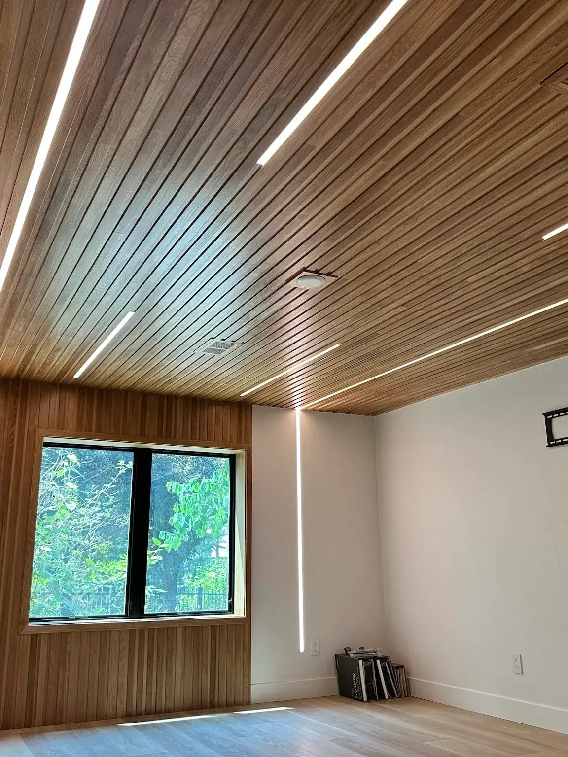 Modern room with wooden ceiling and window.