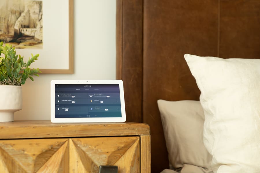 Tablet on bedside table displaying the Control4 home automation interface.